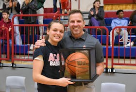 Acadia Axewomen head coach Len Harvey presents Haley McDonald with the game ball Oct. 29 after the Port Williams resident broke the program’s all-time career scoring record.
Peter Oleskevich • Acadia Athletics
