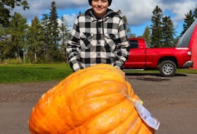 Harrison Yeo stands in front of the giant pumpkin he and his brother, Will, grew together. It placed 9th in the the giant pumpkin weigh-off on Oct. 9, 2021 in York, P.E.I. File