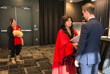Margaret Cranford presents the "Building Trust, Restoring Confidence" report to Justice Minister John Hogan Tuesday, Oct. 4, as Mi'kmaw elder Marjorie Muise drums and sings in the background.
