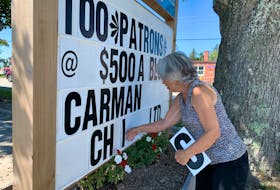 Evelyn Brannen, chair of the Barrington Leisure Park Association, posts the name of a business that has supported the 100 Patrons for Play fundraiser on the sign at the community park in Barrington Passage. KATHY JOHNSON