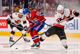 Montreal Canadiens forward Cole Caufield (22) takes the puck away from Ottawa Senators forward Shane Pinto (57) during the third period at the Bell Centre. 