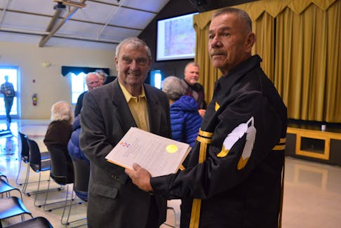 Roland (Rollie) Thornhill, left, hands the land deed for 60 acres near Wagmatcook to Chief Norman Bernard on Tuesday. The land transfer is an act of reconciliation which gives the 60 acres back to the rightful owners. NICOLE SULLIVAN • CAPE BRETON POST