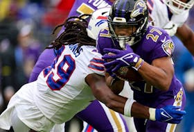 J.K. Dobbins of the Baltimore Ravens runs with the ball while being tackled by Tremaine Edmunds of the Buffalo Bills in the first quarter  at M&amp;T Bank Stadium on October 02, 2022 in Baltimore, Maryland.