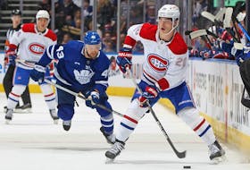 Montreal Canadiens' Juraj Slafkovsky handles the puck against Kyle Clifford of the Toronto Maple Leafs during an preseason game at Scotiabank Arena on Sept. 28, 2022, in Toronto.