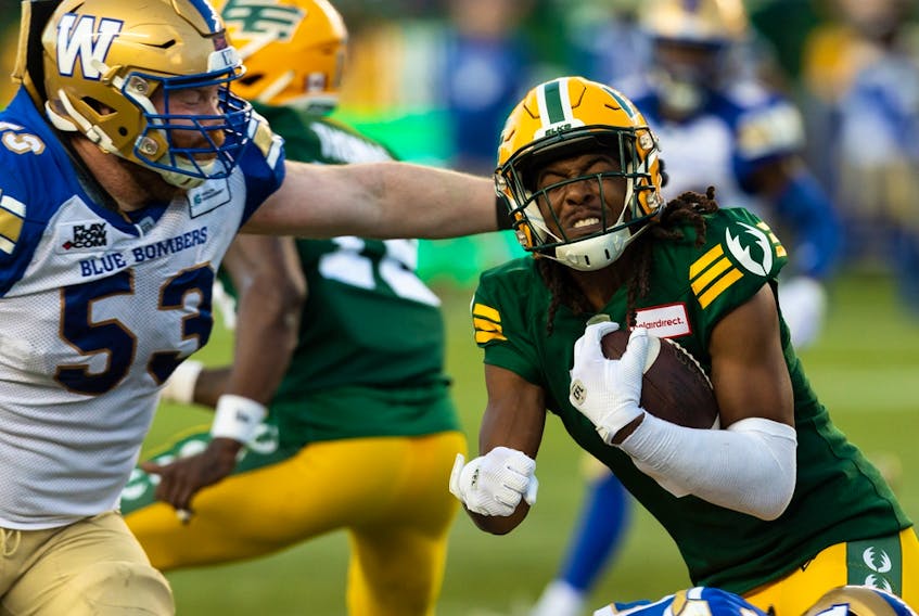 Edmonton Elks defensive back Duron Carter (8) is tackled by Winnipeg Blue Bombers’ Patrick Neufeld (53) after an interception at Commonwealth Stadium in Edmonton on July 22, 2022.