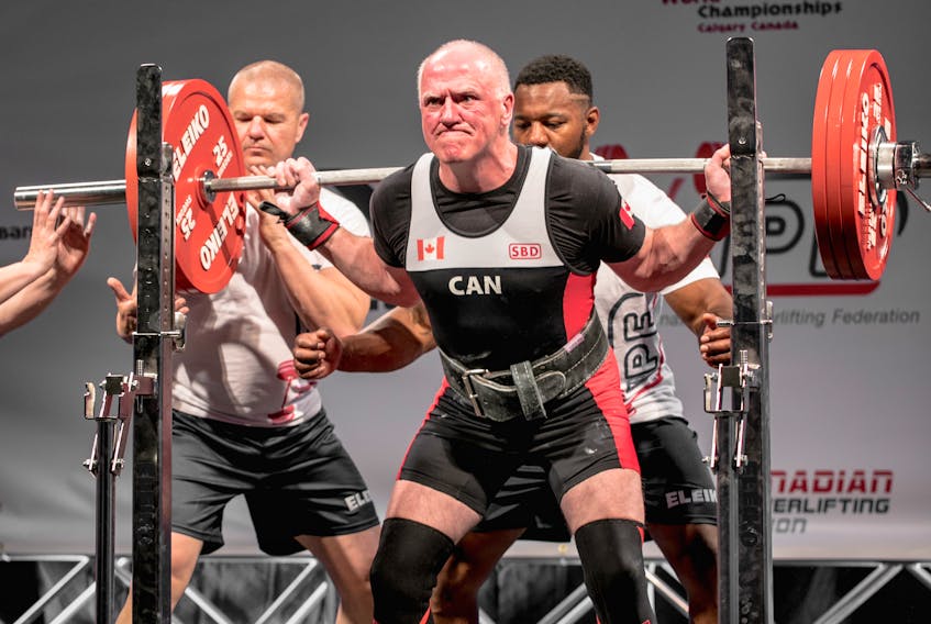 In this file photo, Ron Delaney of Sydney attempts a 391-pound squat while competing at the 2018 International Powerlifting Federation Classic World Championships in Calgary. Now 70-years-old, Delaney will attend the 2022 International Powerlifting Federation championships in St. John’s, N.L., beginning today. PHOTO CONTRIBUTED.