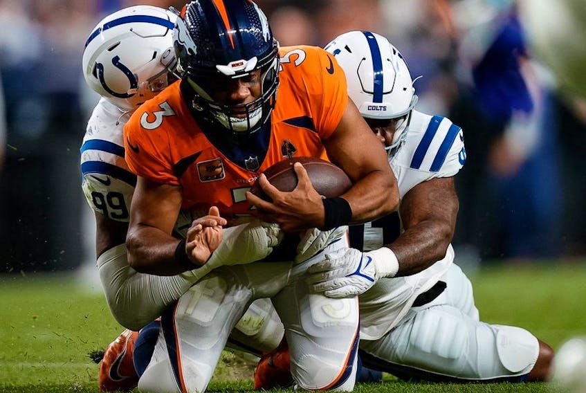 Oct 6, 2022; Denver, Colorado, USA; Denver Broncos quarterback Russell Wilson (3) is tackled by Indianapolis Colts defensive tackle DeForest Buckner (99) and defensive end Yannick Ngakoue (91) in the third quarter at Empower Field at Mile High.  