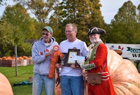 Steam Mill’s Fred Ansems, centre, was all smiles as he received awards from Danny Dill, left, and town crier Lloyd Smith for the heaviest pumpkin. He placed first with his giant gourd weighing in at 1,556 lbs., more than 150 lbs. more than the second-place finisher.
                 Aimee Alden