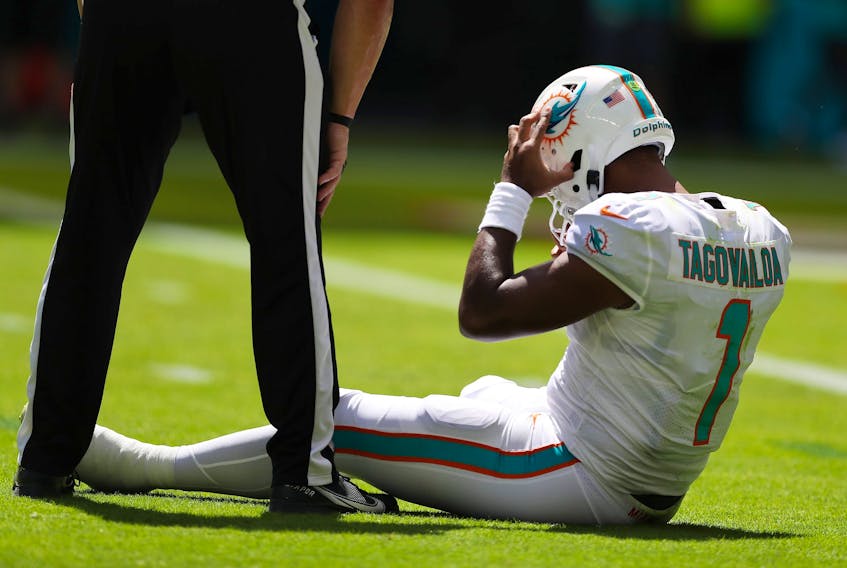Quarterback Tua Tagovailoa of the Miami Dolphins sits on the turf during a game against the Buffalo Bills.