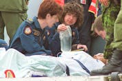  Medics prepare to move Sgt. Lorne Ford out of a military plane that landed at the Edmonton International Airport on April 23, 2002.