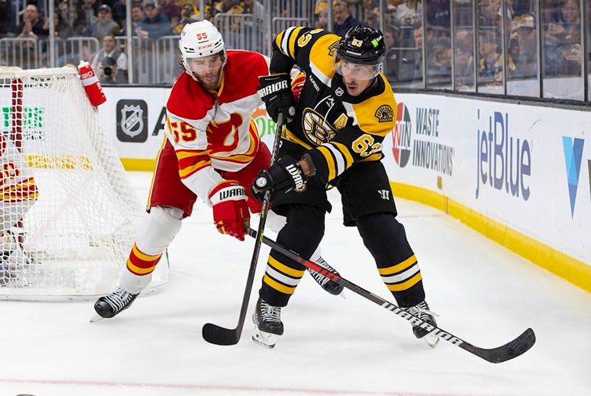 Brad Marchand #63 of the Boston Bruins skates against Noah Hanifin #55 of the Calgary Flames during the first period at the TD Garden on November 10, 2022 in Boston, Massachusetts. The Bruins won 3-1.