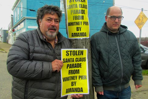 Alan Nathanson, left, president of the Whitney Pier Group Society, with volunteer Drew MacDonald, place signs up accusing the CBRM mayor for allegedly ignoring Whitney Pier residents and their concerns with not including the neighbourhood as part of a Santa Claus parade route. IAN NATHANSON/CAPE BRETON POST