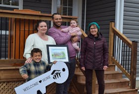 Local artist Lyn-Sue Wice, right, provided this watercolour painting of their new home to the Williams family, Jaxon, left, Kaitlyn, Nelson, and Lila.
