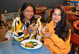 Digital content creator/travel writer Yashy Murphy, left, and food writer Deepi Harish say cheers at Bitter Moon Pub in Glace Bay on Nov. 5 while on assignment in the CBRM. NICOLE SULLIVAN/CAPE BRETON POST