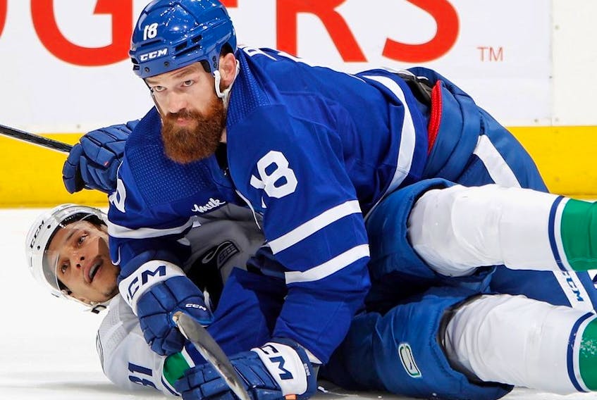 Jordie Benn of the Toronto Maple Leafs and Dakota Joshua of the Vancouver Canucks gets tangled up during the third period at the Scotiabank Arena on November 12, 2022 in Toronto, Ontario, Canada. 