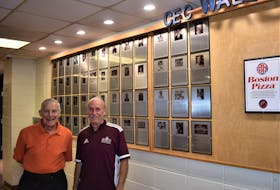 Bob Piers (left) and Scott Annand stand beside the CEC Wall of Fame which will add six new names during a ceremony later this month. Annand, a contributor on many levels to CEC athletics, is one of the six folks to be inducted.