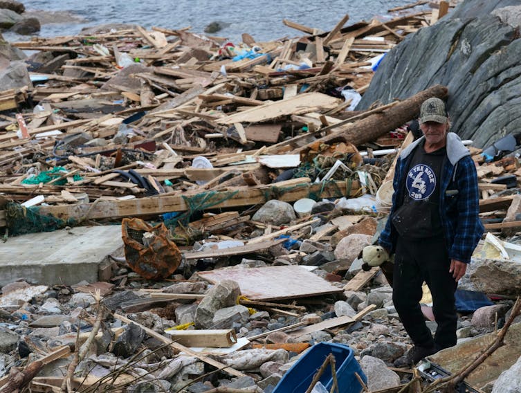 A resident of Port aux Basques walks amongst the refuse of homes destroyed by post-tropical storm Fiona.