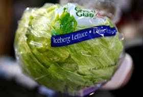 An Iceberg lettuce is removed from a box at a vegetable market, in London, Britain, on Feb. 3, 2017. - Peter Nicholls / Reuters / File