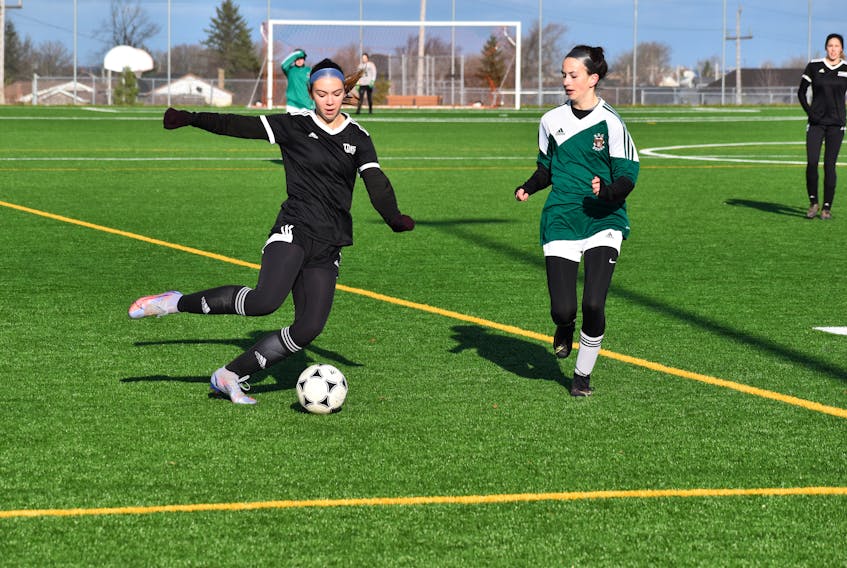 Jillian George of the Northeast Kings Education Centre Titans, left, prepares to cross the ball into the box as she’s pressured by Emily Burke of the Breton Education Centre Bears during School Sport Nova Scotia Division 2 girls’ provincial semifinal action at McKinnon Field in New Waterford on Friday. BEC won the game in penalty kicks, advancing to the championship game. JEREMY FRASER/CAPE BRETON POST.