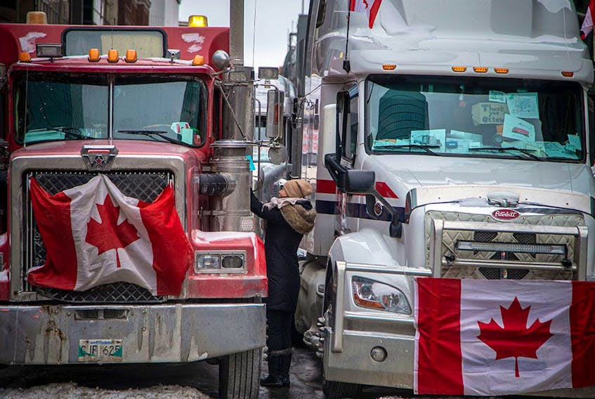 A woman greets a truck driver on Feb. 6, 2022, during the Freedom Convoy's protests in downtown Ottawa. An inquiry into the Liberal government's use of the Emergencies Act to end the protest began this week.