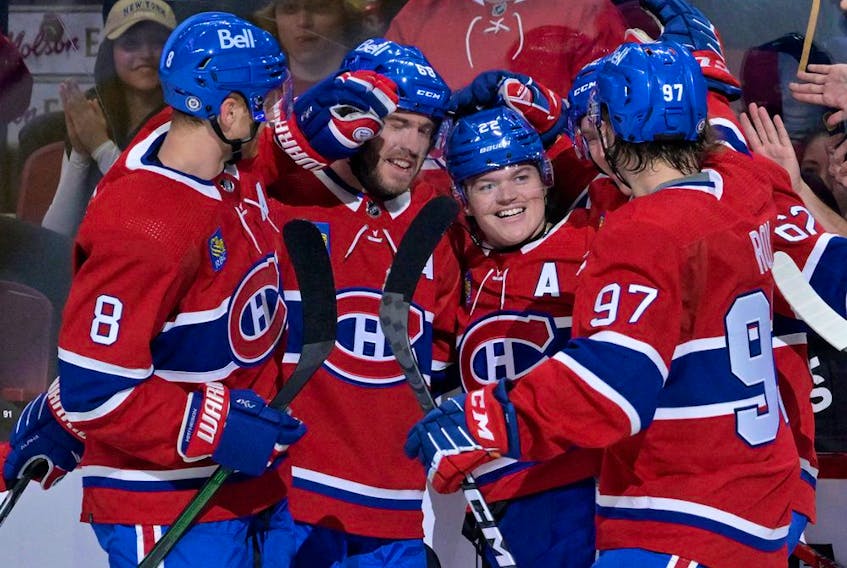 Canadiens defenceman Mike Matheson, left, celebrates Cole Caufield's goal with teammates during preseason game against the New Jersey Devils at the Bell Centre in Montreal on Sept. 26, 2022.