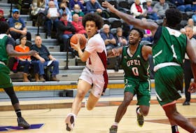 UNB’s Marcus Barnes splits UPEI Panthers defenders during the Reds' 82-79 win on Nov. 19 in Fredericton. James West • Special to The Guardian