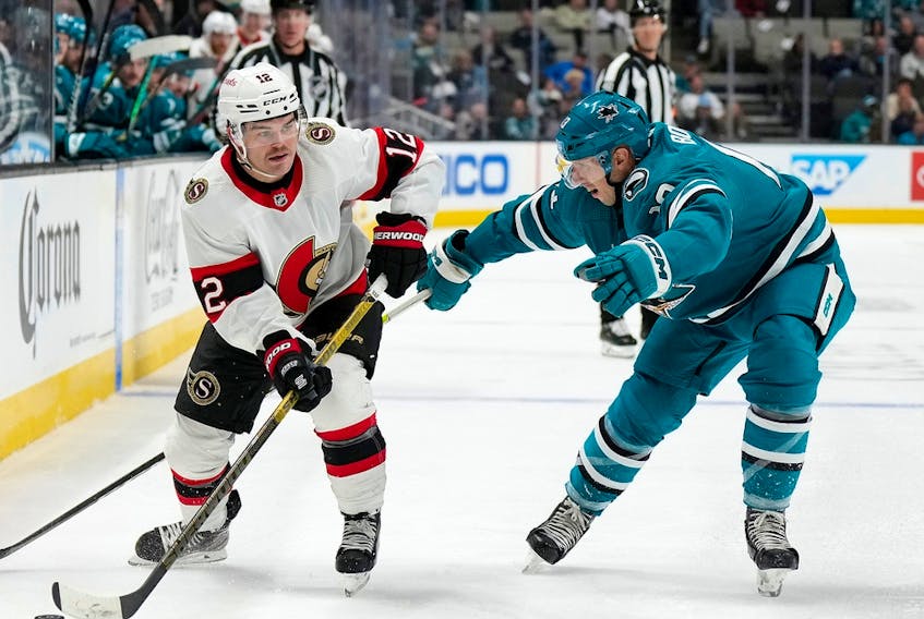  Alex DeBrincat #12 of the Ottawa Senators skates with the puck defended by Nick Bonino #13 of the San Jose Sharks during the third period of an NHL hockey game at SAP Center on November 21, 2022 in San Jose, California. The Sharks won the game 5-1.