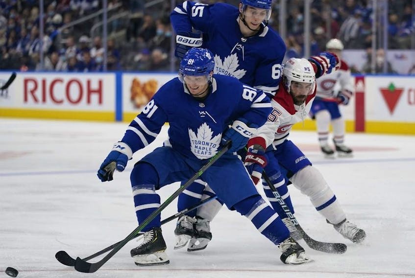Toronto Maple Leafs defenseman Mac Hollowell (81) tries to control the puck as forward Ilya Mikheyev (65) blocks out Montreal Canadiens forward Mathieu Perreault (85) during the second period at Scotiabank Arena. 