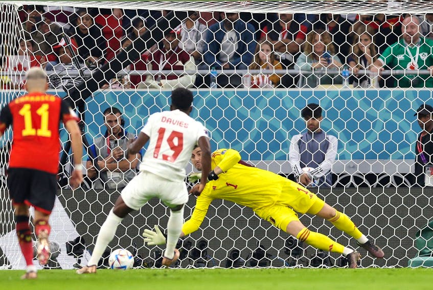 Thibaut Courtois of Belgium saves the penalty taken by Alphonso Davies of Canada.