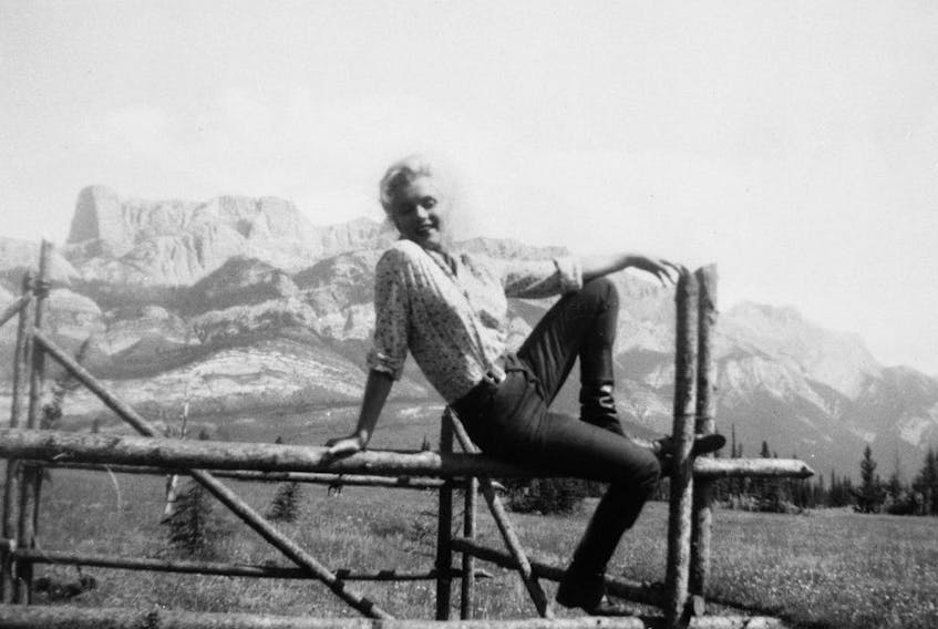 From Mary Graham's A Stunning Backdrop: Alberta in the Movies, 1917-1960, published by Big Horn Books. Marilyn Monroe on a fence at Devona Siding near Jasper, Alberta in "sewn-on" blue jeans for River of No Return in 1953. Bini Furhmann Fonds, v212–pa417–51. Courtesy of the Archives and Library, Whyte Museum of the Canadian Rockies, Banff, Alberta.