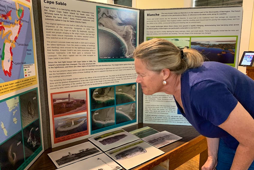 Cape Sable Historical Society member Julie Smith reads one of the panels in the climate change exhibit at the Barrington Museum Complex. KATHY JOHNSON