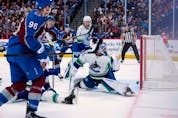  Vancouver Canucks goaltender Spencer Martin (30) lets a goal slip past off the stick of Colorado Avalanche right wing Mikko Rantanen (96) during the first period of an NHL hockey game Wednesday, Nov. 23, 2022, in Denver.