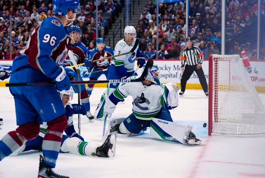  Vancouver Canucks goaltender Spencer Martin (30) lets a goal slip past off the stick of Colorado Avalanche right wing Mikko Rantanen (96) during the first period of an NHL hockey game Wednesday, Nov. 23, 2022, in Denver.