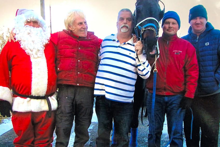 Eddie Brookman, aka Santa Claus, is shown here with his usual Christmas posse who have helped him over the years with his annual ride through Whitney Pier. Brookman will be back again this year after being coached out of retirement. Lending a hand with Santa are Paul Whalen, second from left, Mark Brookman, holding the reins of Dragonfire, Jessie Pearson and Wayne Merner. CONTRIBUTED