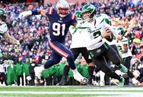 New York Jets quarterback Zach Wilson runs with the ball under pressure from New England Patriots defensive end Deatrich Wise Jr. during the second half at Gillette Stadium. 