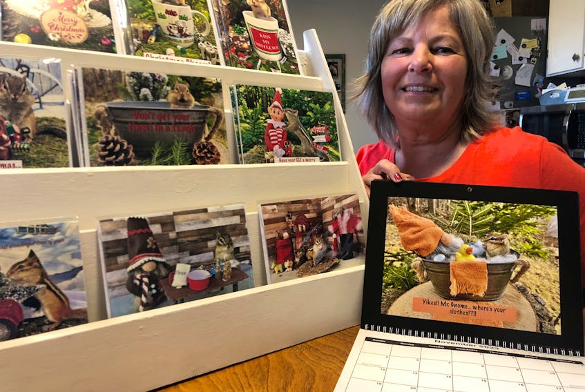 Rachel Goodwin Clark of Trenton displays some of the chipmunk greeting cards she has made from photographs she snapped in her yard. One of her chipmunk calendars is in the foreground. ROSALIE MACEACHERN