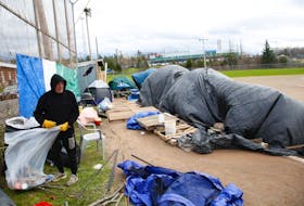 Jamie, who didn't given his last name, cleans up after the previous evening's storm amongst a group of tents belonging to those experiencing homelessness, at a ball field in Lower Sackville on Nov. 17. The seven people who now reside there were all evicted from the closure of the Bluenose Motel earlier this year.