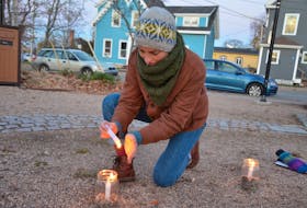 Caroline Beddoe of Wolfville, one of the organizers of the Nov. 18 Candles for Climate rally in Clock Park, lights candles to be used in a gathering circle and a candlelit march down Main Street. KIRK STARRATT