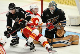 Calgary Flames forward Andrew Mangiapane battles with Washington Capitals defenceman Nick Jensen and goaltender Darcy Kuemper at Capital One Arena in Washington on Friday, Nov. 25, 2022.