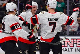 Senators teammates Tim Stutzle (18) and Thomas Chabot celebrate with Brady Tkachuk after he scored a power-play goal against the Ducks in the first period of Friday's game.