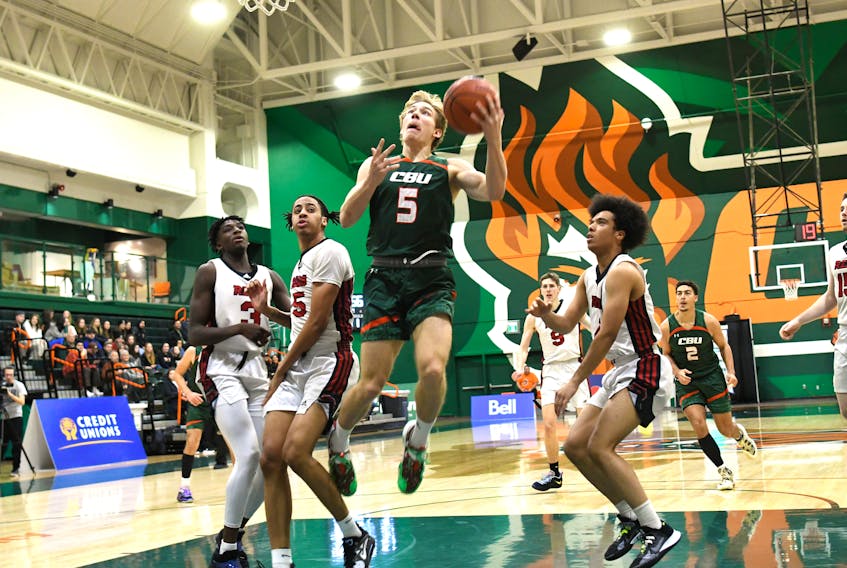 Justus Peuser of the Cape Breton Capers, middle, goes for a lay up during Atlantic University Sport men's basketball action at Sullivan Field House in Sydney on Friday. The New Brunswick Reds won the game 94-85. PHOTO/VAUGHAN MERCHANT, CBU ATHLETICS.
