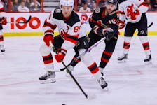 Ottawa Senators left wing Austin Watson  checks New Jersey Devils center Jack Hughes during third period NHL action at the Canadian Tire Centre on Saturday, Nov. 19, 2022.