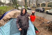Jesse, who only goes by his first name, has set up a perimeter of tree branches around the tent he pitched on a University Avenue median. He's set up Christmas lights and has two small Christmas trees growing in a bucket in his compound.