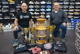 Dwayne McNeill, left, and Dave McNeill pose with some of the prizes that will be awarded at the 25th Edd McNeill Memorial hockey tournament in Summerside from Dec. 1 to 4. Dwayne and Dave are sons of Edd and two of the event organizers. Jason Simmonds • Journal Pioneer