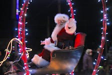 Jolly Old Saint Nicholas waves to people near the intersection of Cottage and Commercial streets who came out to watch Berwick’s Santa Claus Parade on Nov. 26.  
Jason Malloy