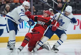 Maple Leafs' Mark Giordano (55) and Calle Jarnkrok (19) knock Red Wings' Lucas Raymond off the puck during the second period on Monday, Nov. 28, 2022, in Detroit. 