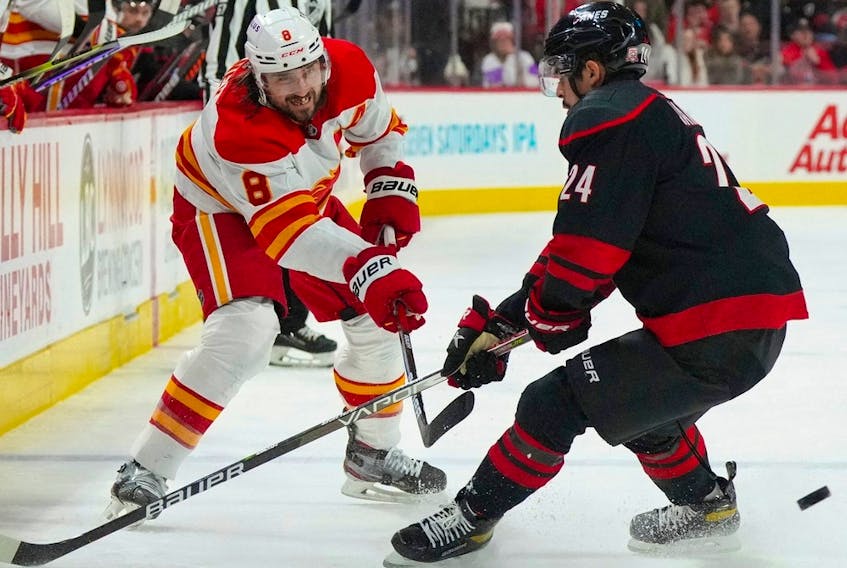 Calgary Flames defenceman Chris Tanev takes a shot past Carolina Hurricanes forward Seth Jarvis at PNC Arena in Raleigh, N.C., on Nov. 26, 2022. 