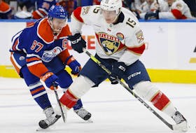 Edmonton Oilers forward Connor McDavid tries to knock the puck away from Florida Panthers forward Anton Lundell during the second period at Rogers Place.  