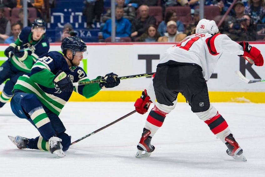  Vancouver Canucks forward Elias Pettersson (40) shoots past New Jersey Devils forward Dawson Mercer (91) in the first period at Rogers Arena on Tuesday night.