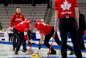 Team Canada's Geoff Walker and E.J. Harnden sweep a stone from Brad Gushue at the Pan Continental Curling Championships in Calgary, Alta.